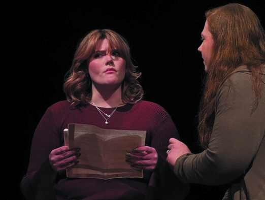 Two actresses perform a scene.