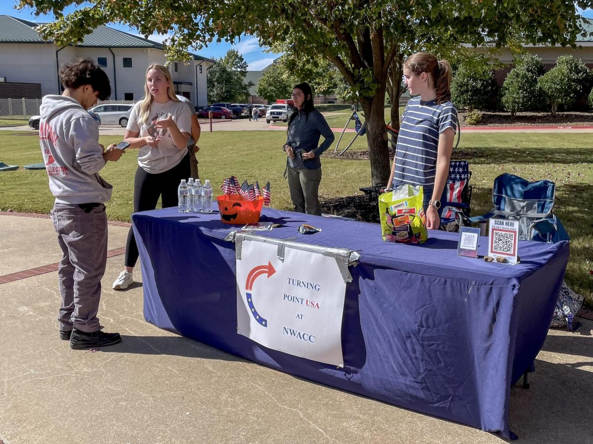 Members of the new Turning Point USA chapter at NWACC staff a table in October to provide information to students.