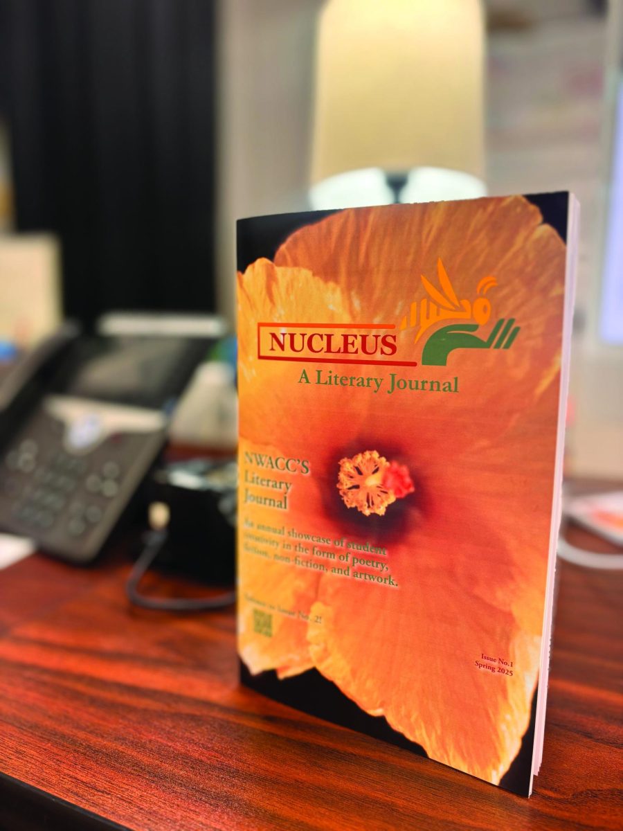 A booklet cover stands up on a table. The cover is for the literary magazine, Nucleus.