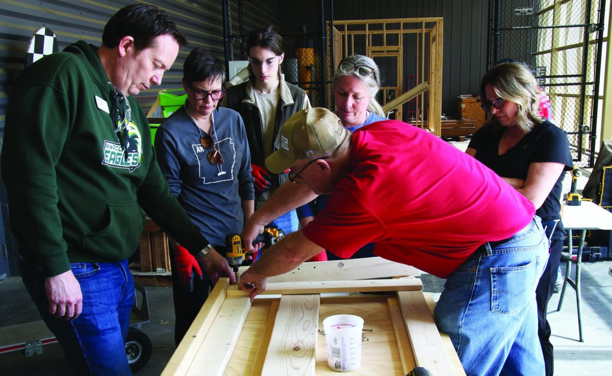 Volunteers prepare the lumber being used to build beds on March 13.