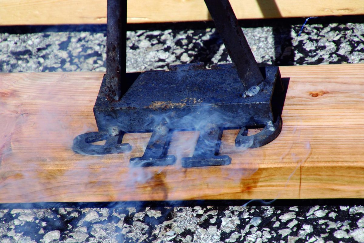 A heated piece of metal sears the logo for Sleep in Heavenly Peace into a board for one of the beds.
