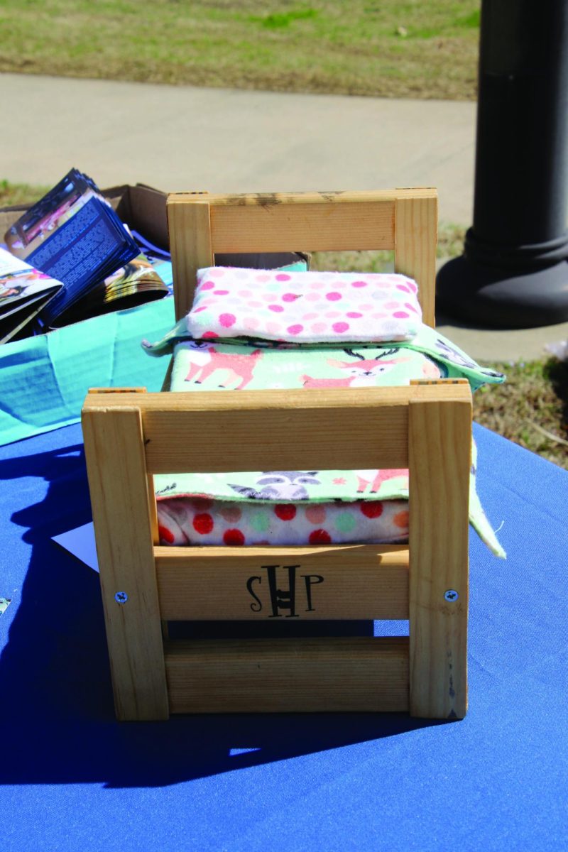 A small wooden bed frame contains a mattress and bed linens.