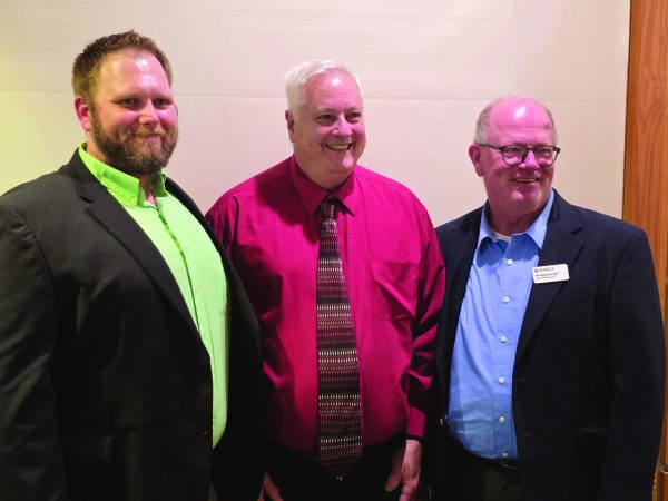 Three men are standing together and smiling. The man in the center, Jamin Snarr, is the person who was recognized.