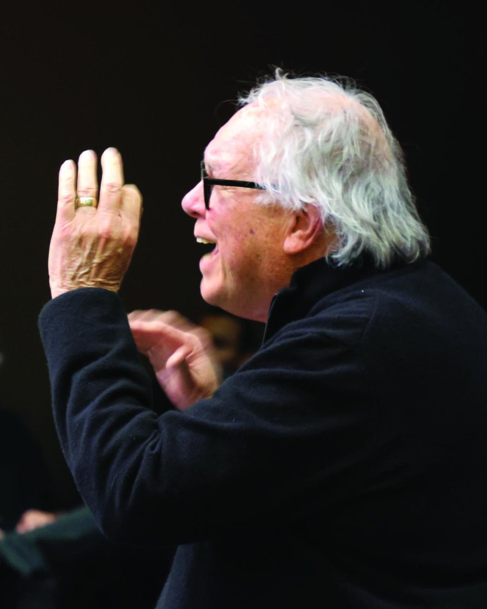 Professor Miles Fish directs vocalists during the musical performance on April 28.