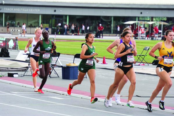 Runners near the finish line in a women's 1500-meter race at the University of Arkansas spring invitational. Two NWACC athletes are among the runners.